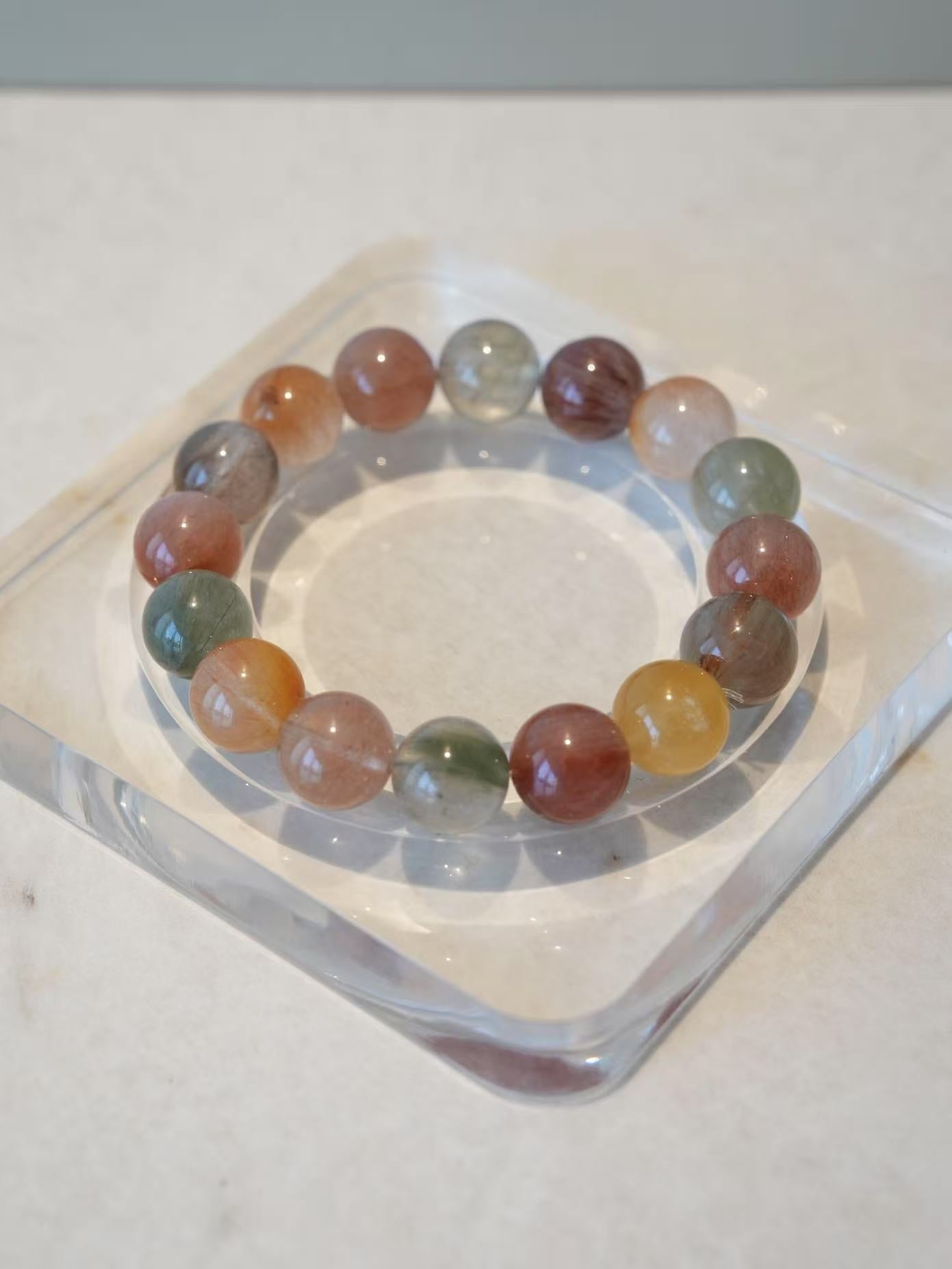 Multicolored beaded bracelet on a clear stand with a white background